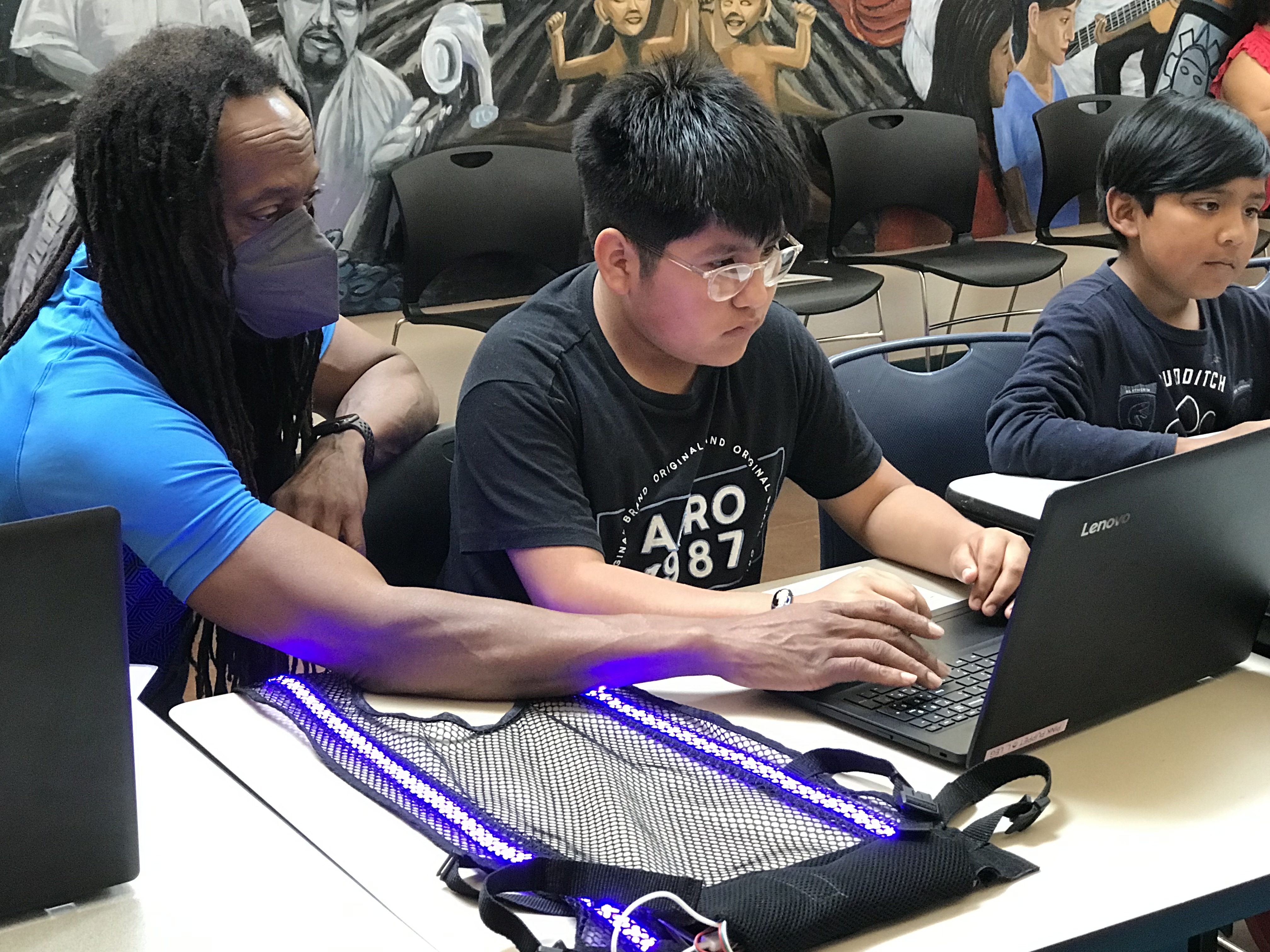 Darryl Thomas teaching kids to code while wearing the glowing iLuma LED vest